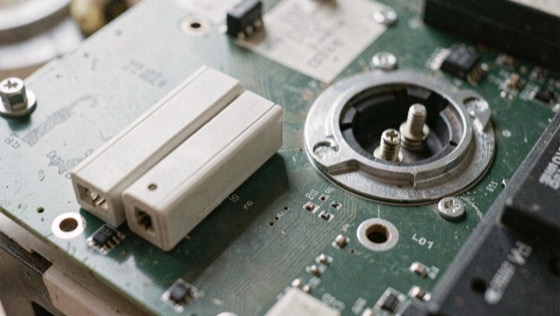Two small storage modules of different lengths lying beside an open socket with its retaining screw and standoff visible on the board